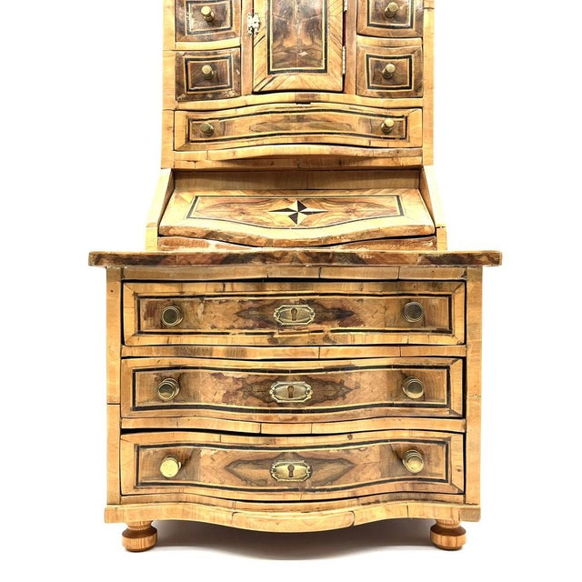 Finely crafted wooden model furniture with intricate inlays and burl wood veneer. The small drawers and compartments are...