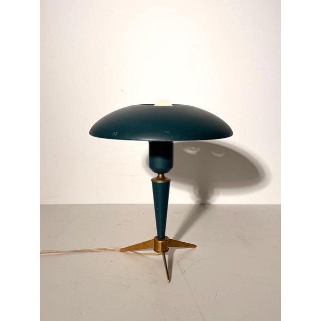 A distinctive Philips table lamp designed by Louis Kalff, featuring a broad dome shade, tapered stem and sculptural tripod...