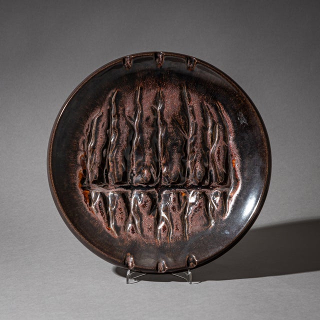 Set of two ceramic bowls with a dark brown glaze and asymmetrical, organic forms in the well. The larger piece measures H:...