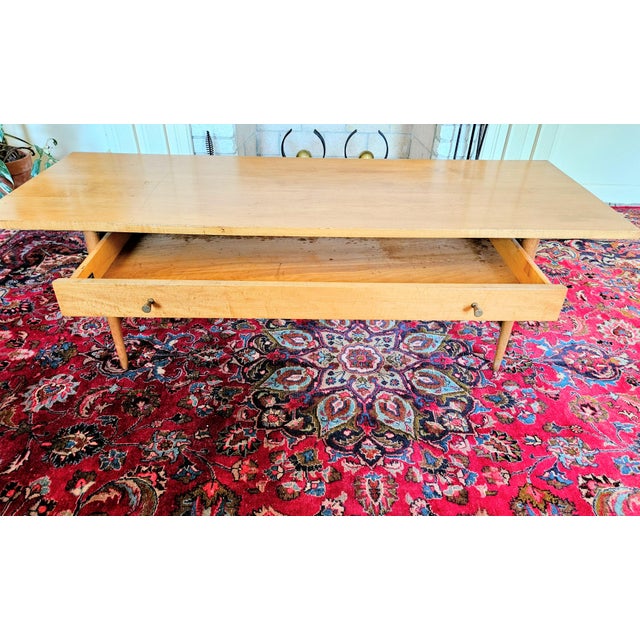 A Mid Century Modern Paul McCobb Planner Group Coffee Table with Drawer. The table is built of solid maple wood and is...