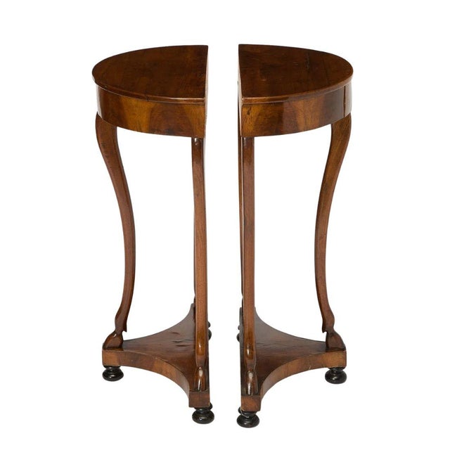 Late 19th century pair of Italian walnut demi-lune console tables with a concealed drawer and three graceful cabriole legs...