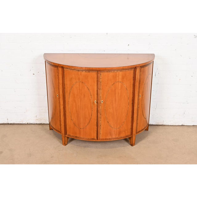 A gorgeous Federal or Hepplewhite style demilune sideboard, cabinet, or console table By Baker Furniture, "Colonial...