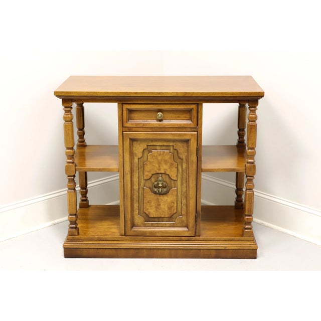 A Mediterranean style console cabinet with open shelves by Bernhardt. Walnut with a distressed finish, burl to door front,...