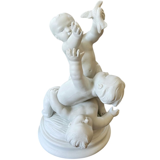 A beautifully modeled French bisque porcelain sculpture by Edmé Samson et Cie, Paris, depicting three playful children...