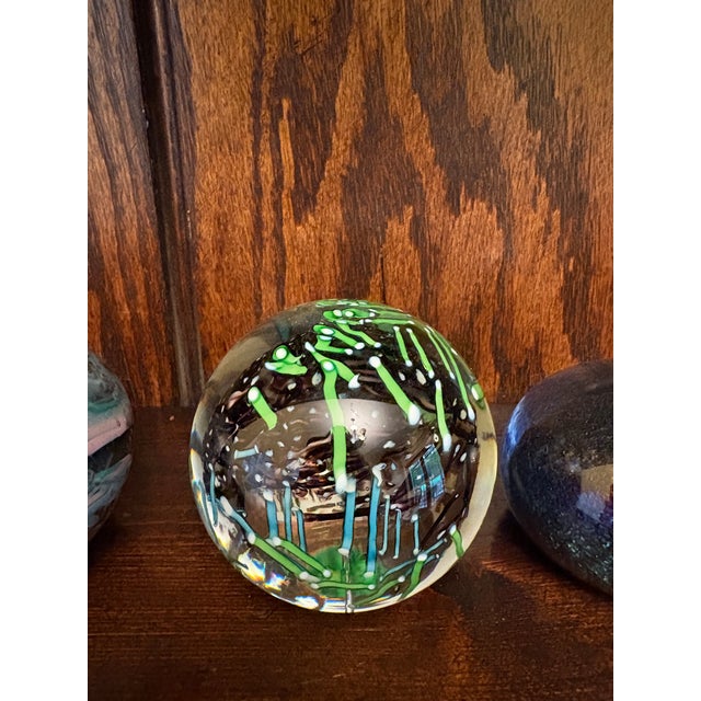 This listing features a set of four vintage studio art glass paperweights, offered together as a curated bundle. The...