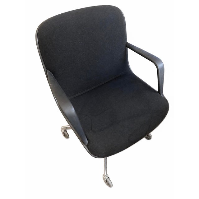 A pair of vintage Steelcase executive swivel chairs with black upholstery, integrated arms, and aluminum four-star caster...