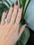 A 3.00-carat rainbow moonstone cabochon sits at the centre of this solid 14K rose gold ring, framed by eight earth-mined...