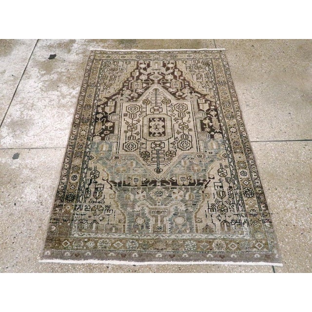 This mid-20th-century Persian Malayer rug presents a compact geometric composition in muted brown, taupe, beige, ivory,...