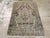 This mid-20th-century Persian Malayer rug presents a compact geometric composition in muted brown, taupe, beige, ivory,...