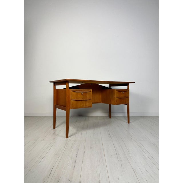 Vintage Mid-Century Modern teak writing desk in a minimalistic design with a compact tabletop. Drawer compartment on the...