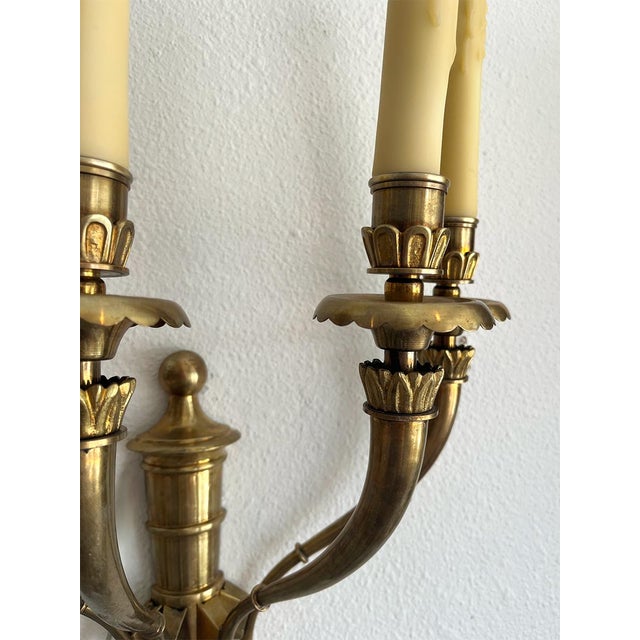 Each sconce has four lights. These are in great condition and feature a slightly floral motif at the base of each light.