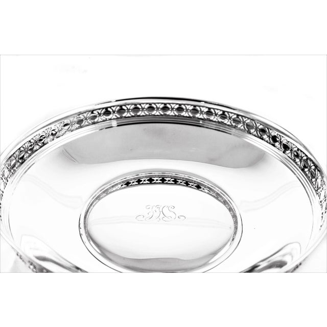 This reticulated bowl by Tiffany and Company has a cut-out design around the edge. It has a curved shape on the sides and...