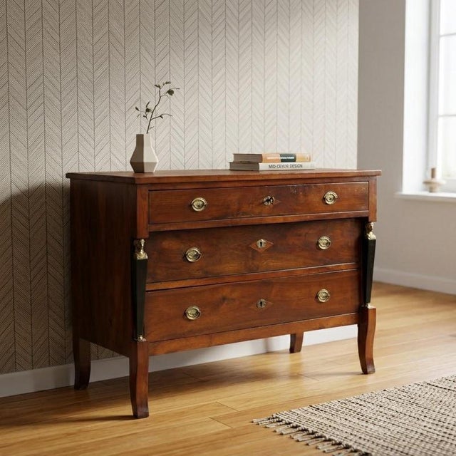 Empire walnut chest of drawers. Three drawers in the front, the first of which is projecting, supported by truncated...
