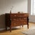Empire walnut chest of drawers. Three drawers in the front, the first of which is projecting, supported by truncated...