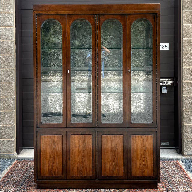 A vintage Henredon Fine Furniture Mid Century Modern lighted bar cabinet in dark oak with golden brown lower doors....
