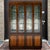 A vintage Henredon Fine Furniture Mid Century Modern lighted bar cabinet in dark oak with golden brown lower doors....