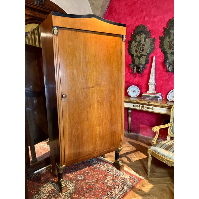Elegant 19th century biedermeier fruitwood armoire with dolphin carvings, gilt details, and urn shape. A rare italian...