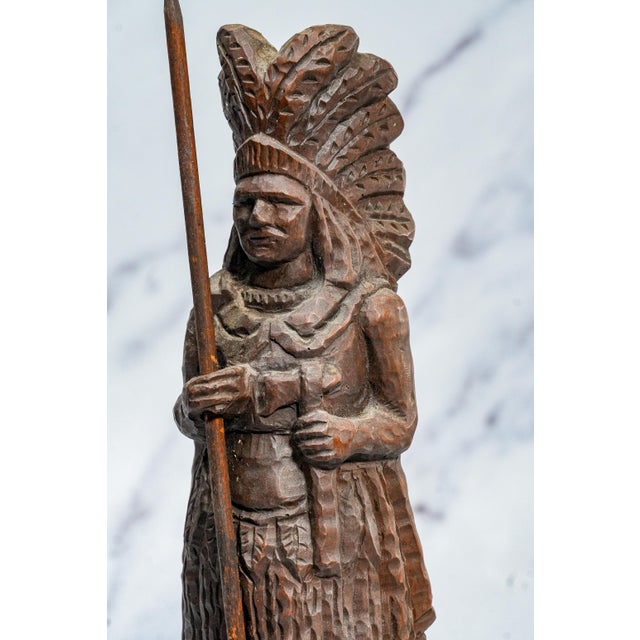 This striking circa 1900 solid wood carved sculpture depicts a Native American chief rendered with remarkable presence and...