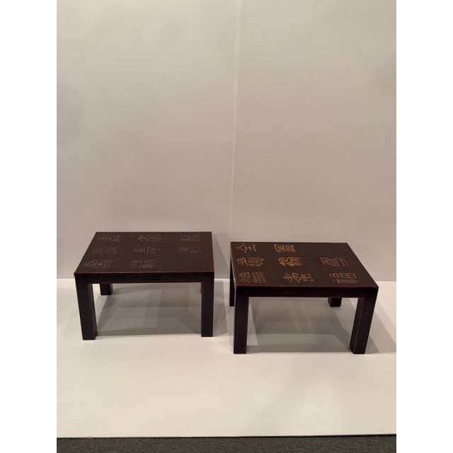 Chic pair of vintage Chinese cordovan brown end tables having gold Chinese characters incised on them and a red band of...