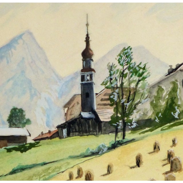 Original vintage European watercolor painting of hay bales with steeple in background., circa 1960. Displayed on a white...
