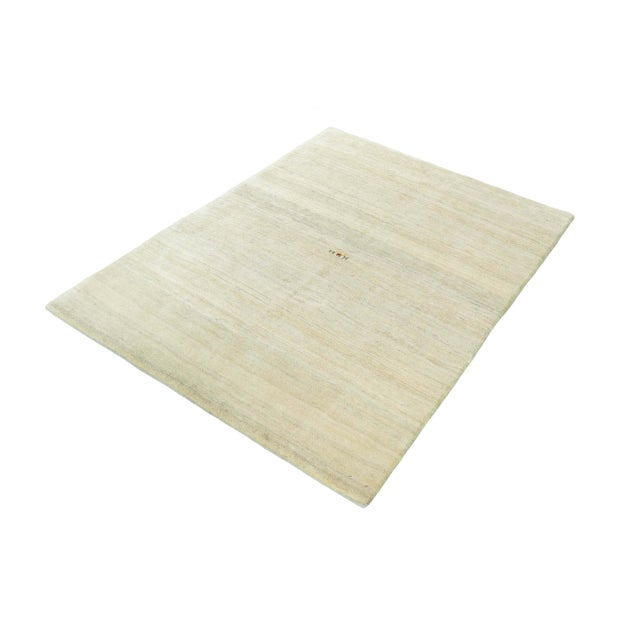 This hand-knotted Gabbeh Loribaft rug combines traditional nomadic craftsmanship with modern minimalism. The subtle cream-...