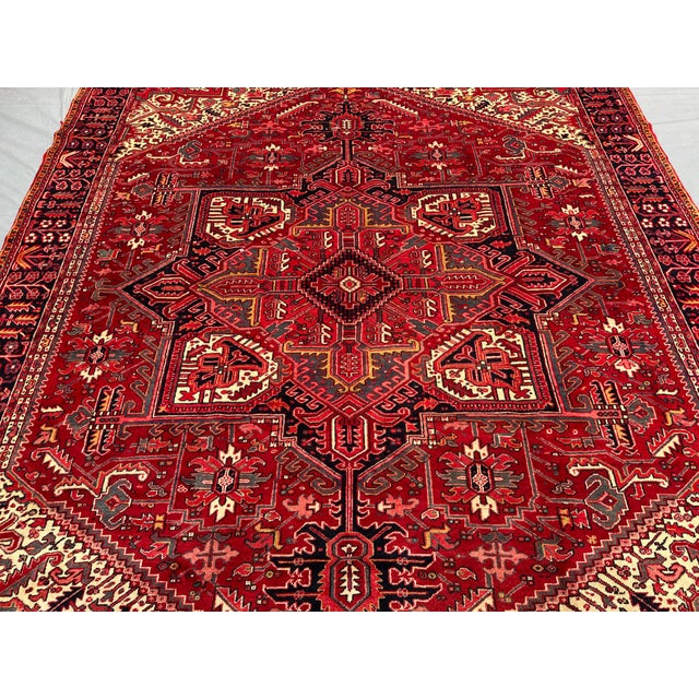 This magnificent vintage rug, hand-knotted in the 1970s, showcases a bold Heriz design with intricate geometric patterns...
