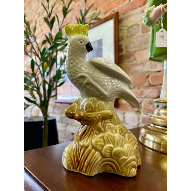 Colorful vintage figurine depicting a cockatoo on a pedestal. Pretty glossy ceramic finish. Measures 7"H. Made in Brazil.