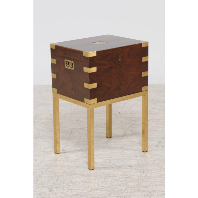 An English flaming mahogany cellarette from the mid-20th century on brass stand. This English wine cooler features a...