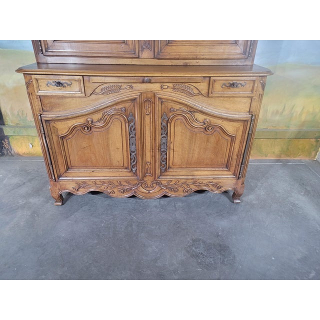 A very elegant two-part louis xv style buffet, crafted from walnut, richly carved and worked. the upper section opens with...