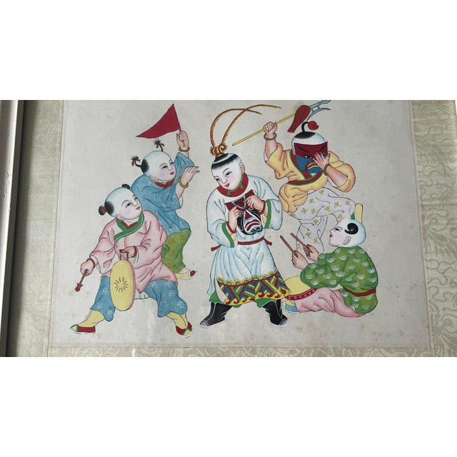 The Antique Oil Painting is on silk. It shows several Chinese children playing with masks, a sword, a flag. The painting...
