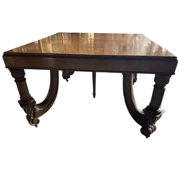 This particular table, with its ornate carved skirt and substantial trestle supports, points to a 20th-century...
