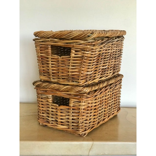 A pair of woven rattan lidded baskets. The lids have an interior oak rim stitched into the underside. The study...