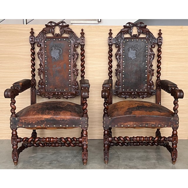 Pair of Spanish Colonial style armchairs, having carving leather seats and backs, brass nailheads and a beautiful patina...