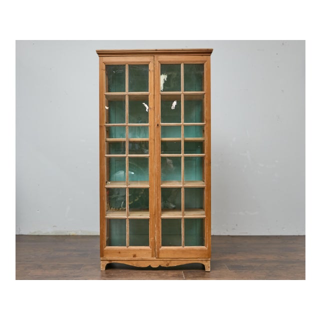 With its tall, narrow silhouette and charming paned glass doors, this 19th-century English pine cabinet invites effortless...