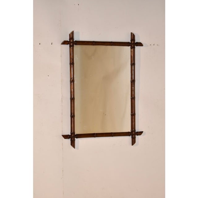 Circa 1900 faux bamboo mirror from France. The frame appears to be made from mahogany and is turned expertly to look like...