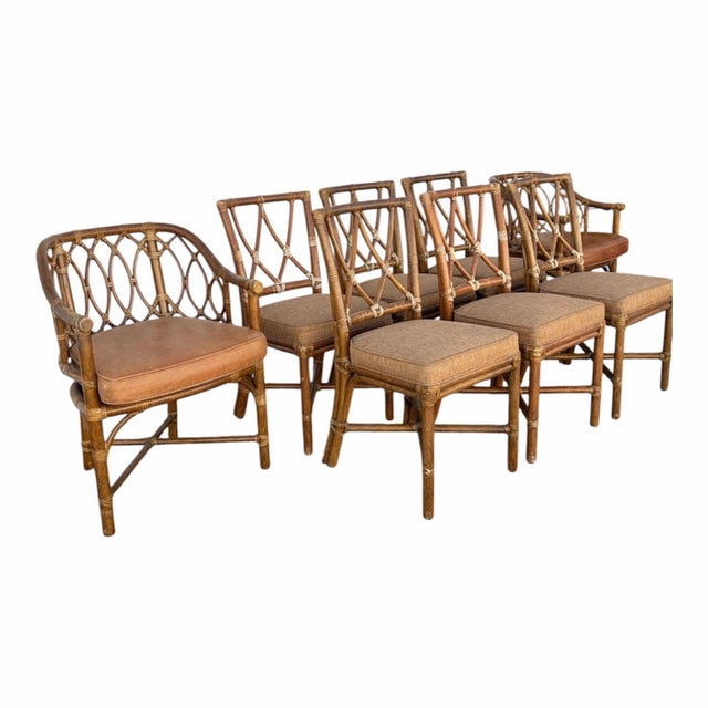 Set of 8 dining chairs by McGuire. Two arm chairs and six side chairs. Constructed of bamboo, rattan, and hide straps....