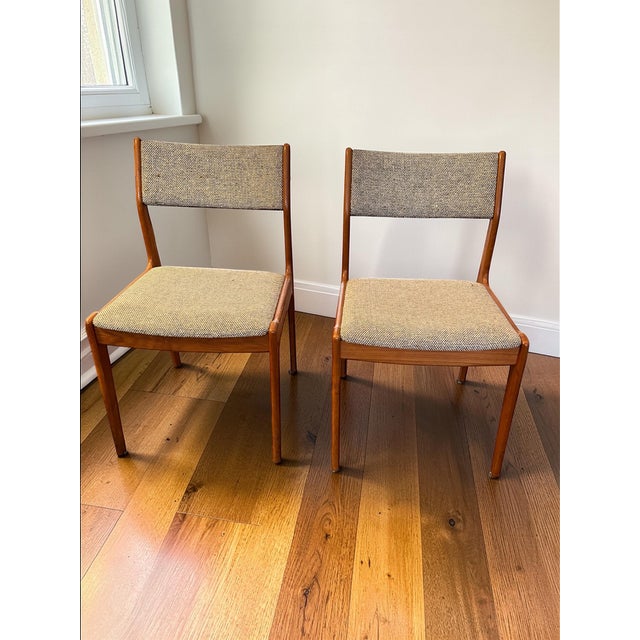 Beautiful pair of Mid-Century Modern dining chairs crafted in warm solid teak, featuring elegant sculptural frames and...