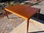 This mid-century modern Danish teak table, popular from the 1950s–1970s, is characterized by a minimalist, organic, and...