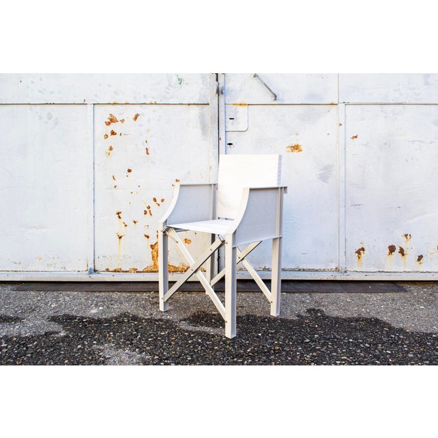 Folding armchair with plastic frame, fabric seat and backrest. Cross the Line Series Saint Ethic Model Designer Philippe...