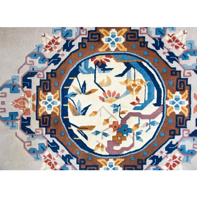 A brilliant mid-20th century Chinese hand-knotted wool rug with a central floral medallion with lotus flowers, bamboo...
