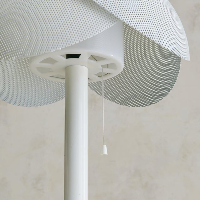 A mid-20th century Italian table lamp, its dome-shaped shade formed from overlapping sheets of perforated white metal. The...