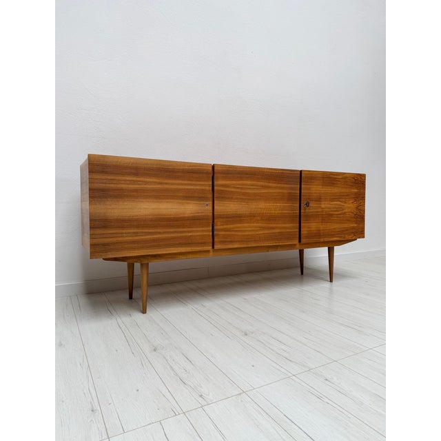 Beautiful german mid-century sideboard from the 1960s, crafted in walnut and characterized by its clean lines, warm wood...