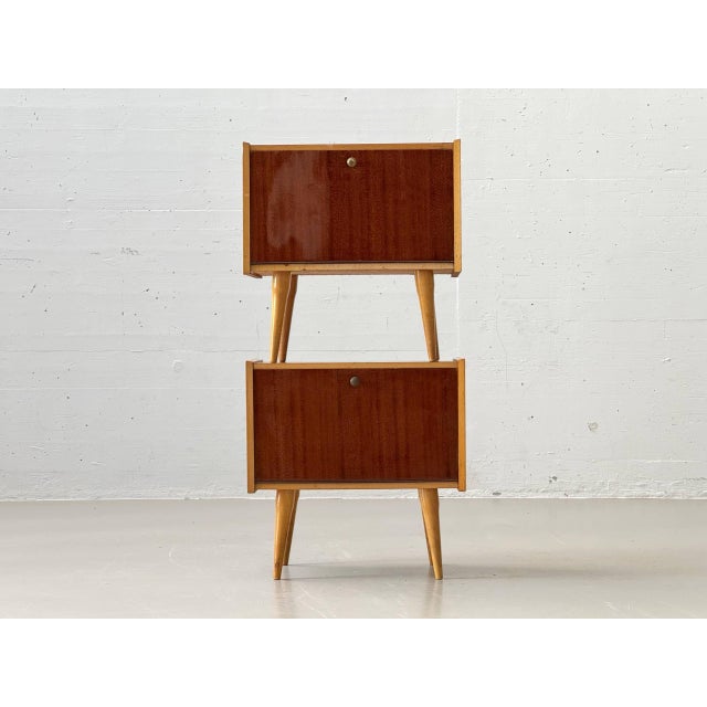 This elegant bedside table embodies the clean, functional design language of the 1950s and impresses with its refined...