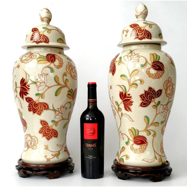 Offering a Monumental pair of vintage beige crackled Chinese porcelain temple jars with burgundy flowers done with satin...