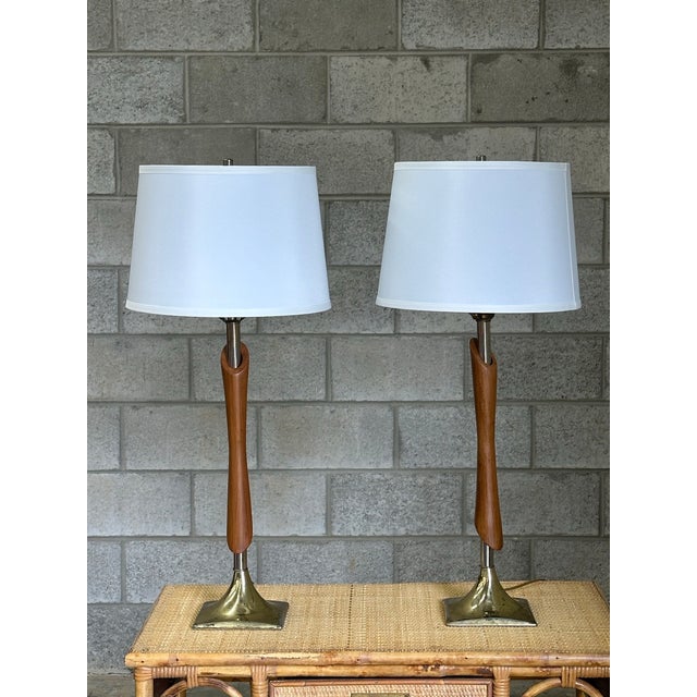 Nice pair of tall lamps in walnut and brass after Laurel. Very nice size lamps and good form. Overall 29.5” tall 13” wide...
