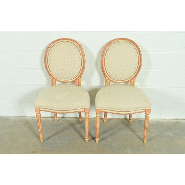 A gorgeous pair of French Regency Louis XVI style side chairs or dining chairs By Baker Furniture USA, Circa 1960s Carved...