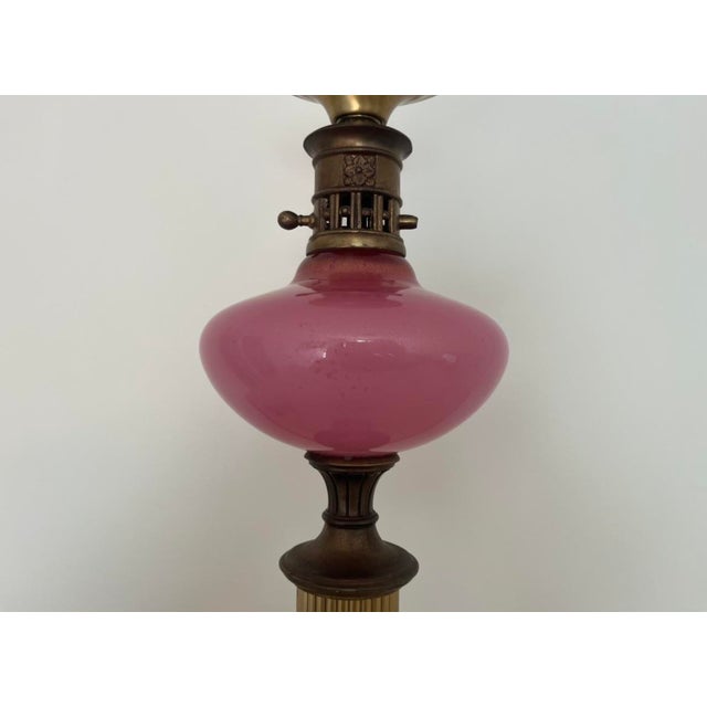 Enjoy this charming vintage lamp. Features opaque pink glass with gold speckles and a white soapstone base. A floral motif...