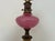 Enjoy this charming vintage lamp. Features opaque pink glass with gold speckles and a white soapstone base. A floral motif...