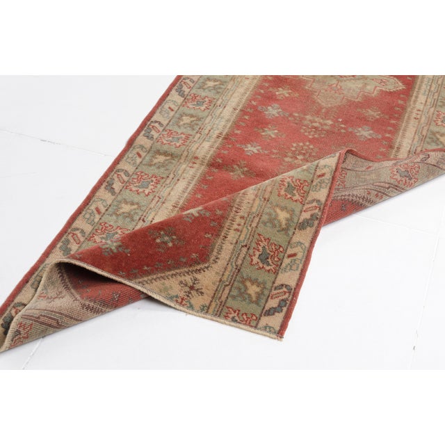 This is a vintage Turkish Oushak rug from the Mid 20th Century. The piece was hand-knotted.