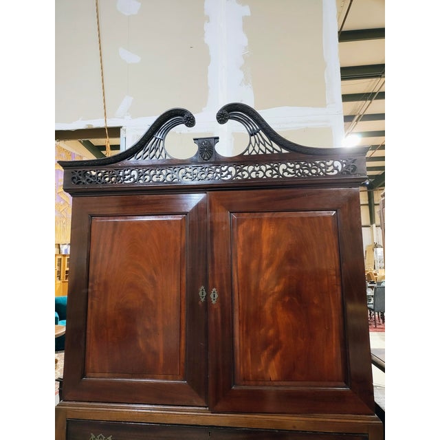 Striking two-part mahogany case piece in the Queen Ann/ Chippendale Revival taste, featuring a dramatic broken swan-neck...